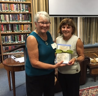 Lori Scudder, President, with winner of a set of Gil's books Mary 
Simonetti
